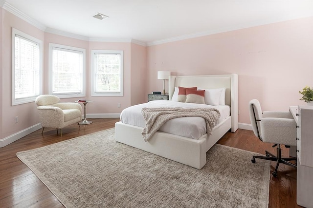 bedroom featuring ornamental molding, wood finished floors, and baseboards