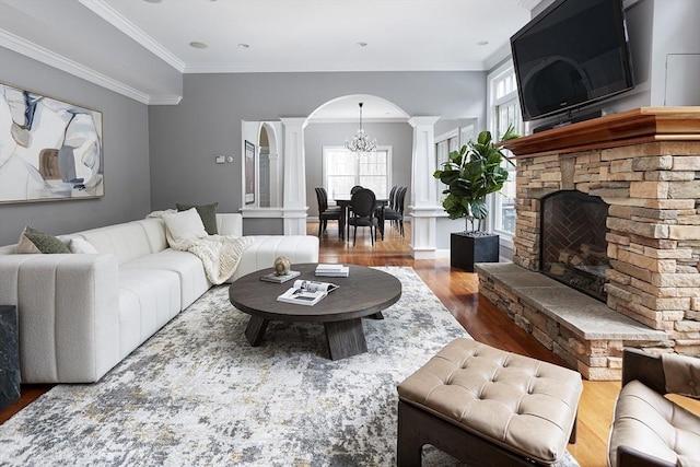 living room with ornamental molding, arched walkways, decorative columns, and wood finished floors