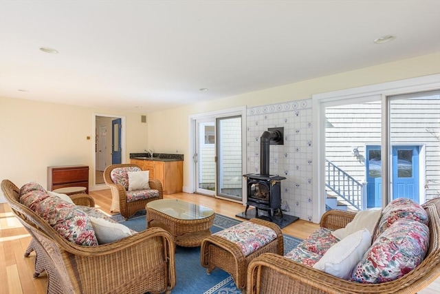 living area featuring a wood stove and light wood-type flooring