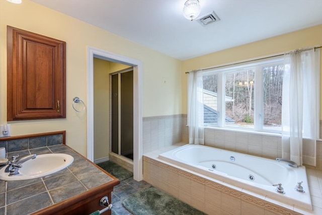 bathroom with tile patterned flooring, visible vents, a whirlpool tub, a stall shower, and a sink