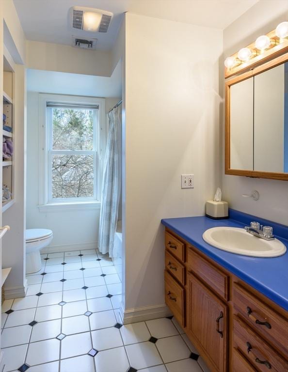 bathroom with visible vents, shower / bathtub combination with curtain, toilet, baseboards, and vanity