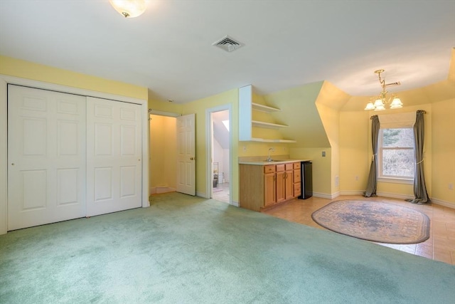 bonus room with a notable chandelier, visible vents, light colored carpet, and a sink