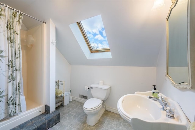 full bath featuring visible vents, a shower stall, toilet, vaulted ceiling with skylight, and a sink