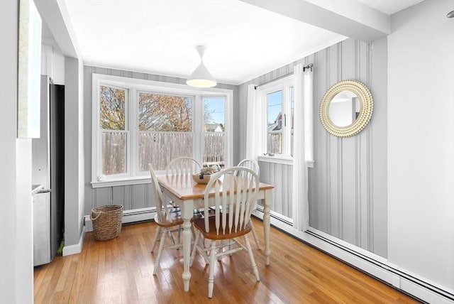 dining area featuring baseboards, a baseboard radiator, and wood-type flooring