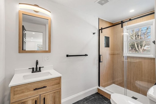 bathroom featuring vanity, a shower with shower door, and toilet