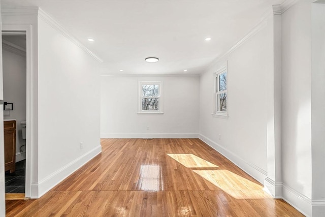 empty room with crown molding and light hardwood / wood-style flooring