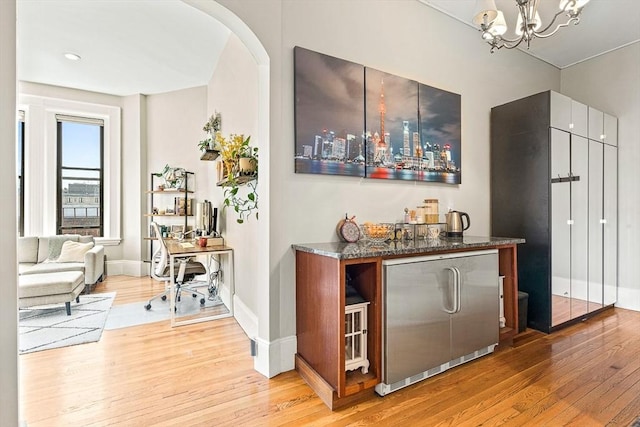 271 Dartmouth St Unit 5C, Boston, MA 02116 - indoor dry bar featuring light wood finished floors, baseboards, a chandelier, and arched walkways