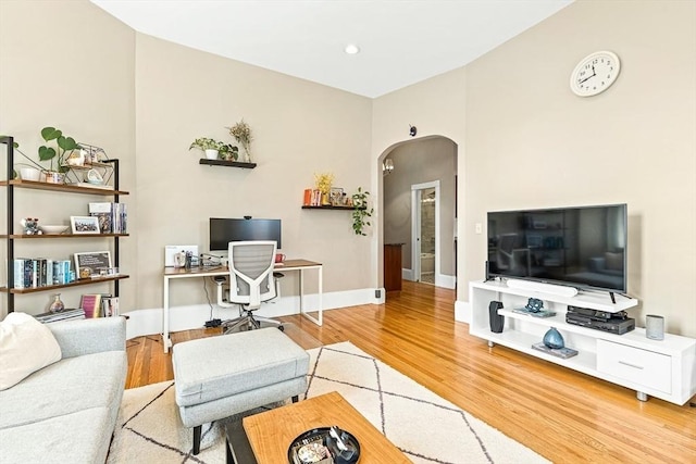 271 Dartmouth St Unit 5C, Boston, MA 02116 - living room featuring arched walkways, wood finished floors, and baseboards