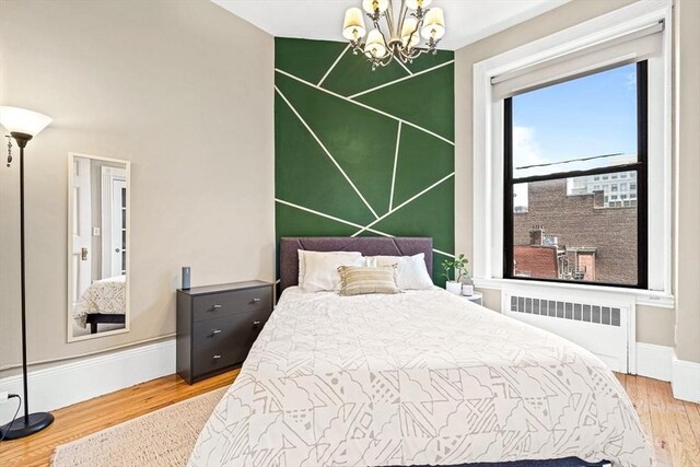 271 Dartmouth St Unit 5C, Boston, MA 02116 - bedroom featuring radiator, wood finished floors, a chandelier, and baseboards