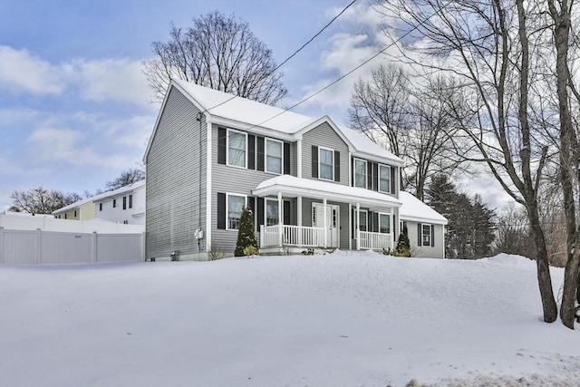 colonial home with a porch and fence