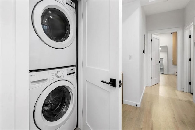 washroom featuring light hardwood / wood-style floors and stacked washer and dryer