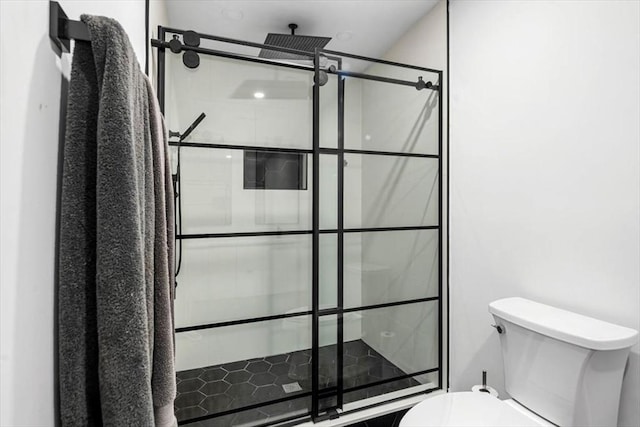 bathroom featuring tiled shower and toilet