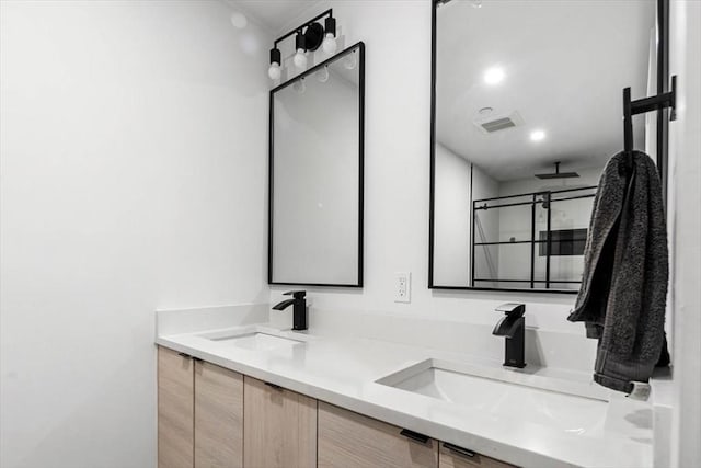 bathroom featuring vanity and a shower with shower door