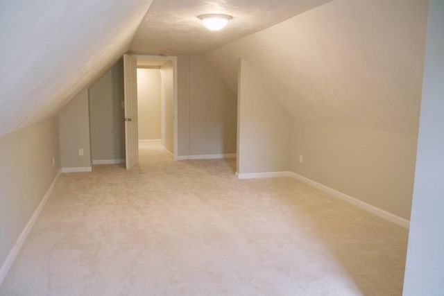 bonus room featuring light carpet and vaulted ceiling