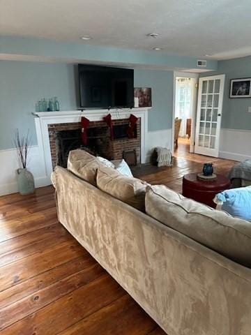 living room with dark hardwood / wood-style floors and a brick fireplace