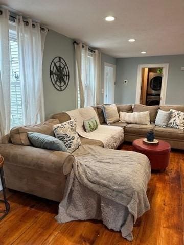 living room featuring hardwood / wood-style flooring and stacked washer and dryer