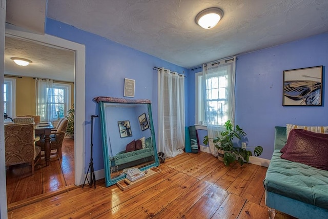 living area with hardwood / wood-style floors and a textured ceiling