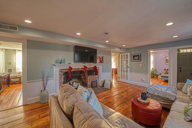 living room featuring light hardwood / wood-style floors and a brick fireplace