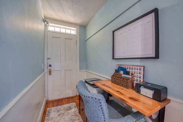 home office featuring wood-type flooring and a textured ceiling