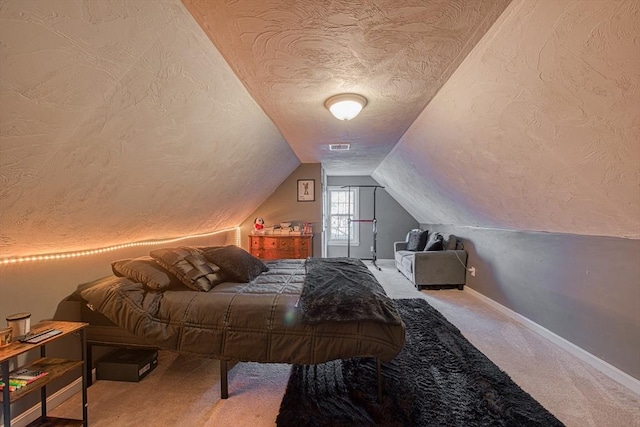 carpeted bedroom with lofted ceiling and a textured ceiling