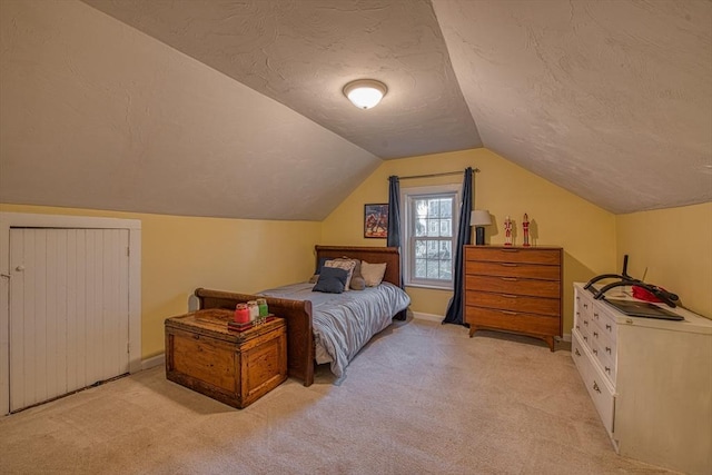 carpeted bedroom featuring a textured ceiling and vaulted ceiling