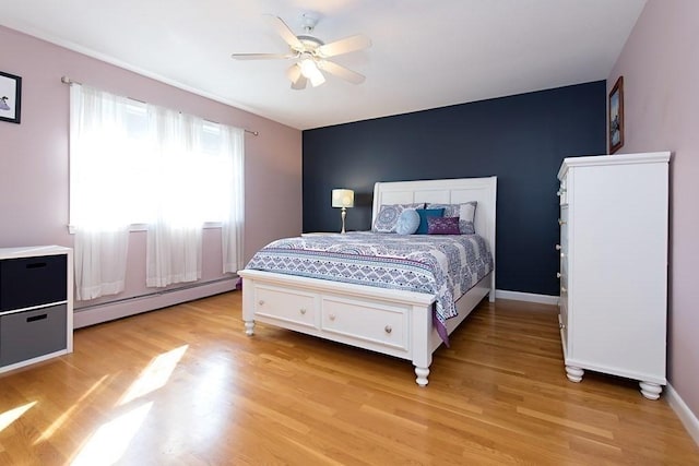 238 Rock St Unit C8, Norwood, MA 02062 - bedroom featuring a baseboard radiator, light wood-type flooring, baseboards, and ceiling fan