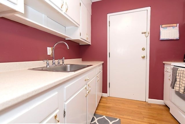 238 Rock St Unit C8, Norwood, MA 02062 - kitchen with a sink, light countertops, stove, white cabinets, and light wood-style floors