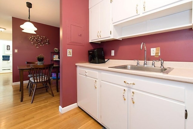 238 Rock St Unit C8, Norwood, MA 02062 - kitchen with a sink, light wood-style floors, white cabinets, light countertops, and decorative light fixtures