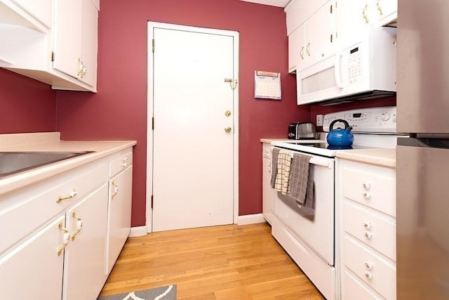 238 Rock St Unit C8, Norwood, MA 02062 - kitchen featuring white appliances, light countertops, light wood-style flooring, and white cabinetry