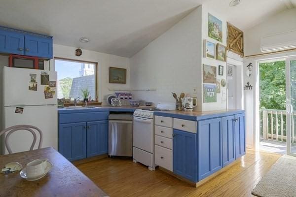 87 Bradford St Unit 3, Provincetown, MA 02657 - kitchen featuring white appliances, blue cabinetry, lofted ceiling, light wood-style floors, and a sink