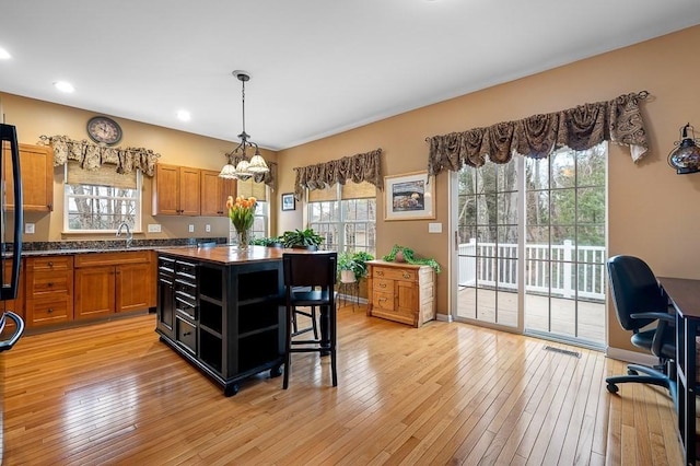 9 Summerfield Dr Unit 8, Grafton, MA 01560 - kitchen with a center island, light wood finished floors, open shelves, visible vents, and brown cabinetry