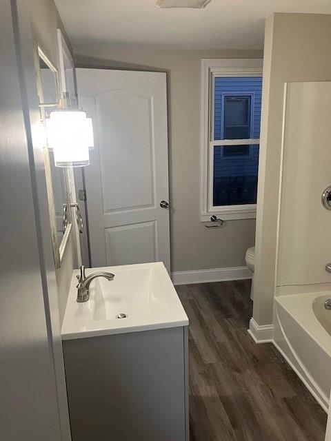 423 Orange St, Springfield, MA 01108 - full bath with wood finished floors, vanity, toilet, baseboards, and shower / tub combination