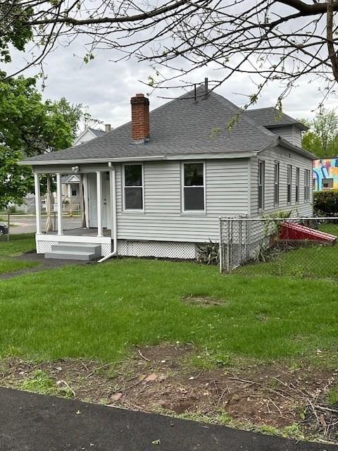 423 Orange St, Springfield, MA 01108 - back of property with a chimney, roof with shingles, and a yard