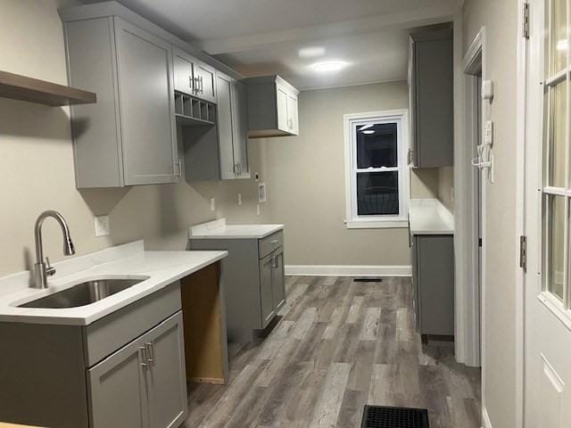 423 Orange St, Springfield, MA 01108 - kitchen featuring a sink, gray cabinetry, dark wood-style flooring, open shelves, and light countertops