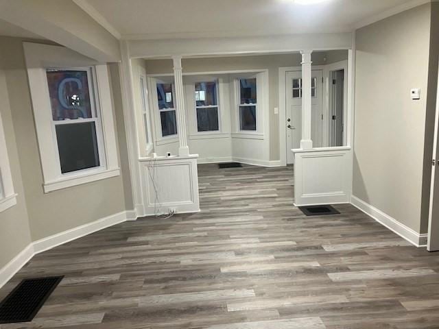 423 Orange St, Springfield, MA 01108 - unfurnished dining area with ornate columns, baseboards, and wood finished floors