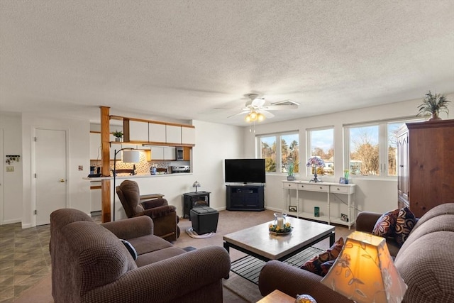 living room with a textured ceiling and ceiling fan