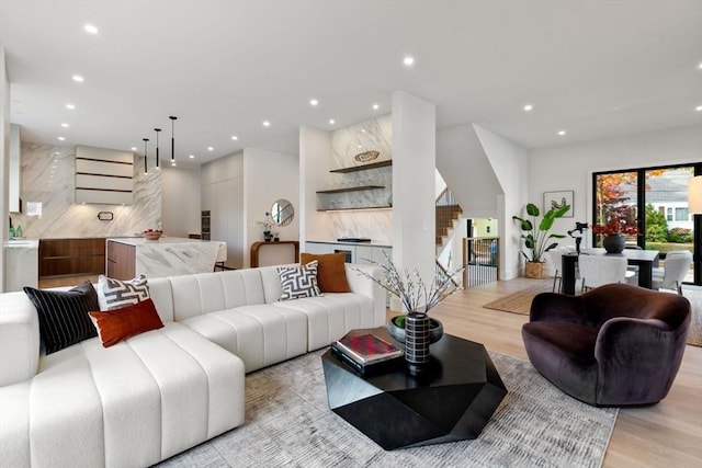 living area with light wood-type flooring, stairs, and recessed lighting