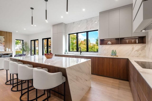 kitchen featuring black electric cooktop, custom range hood, modern cabinets, and open shelves