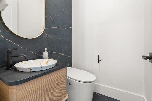 bathroom featuring toilet, backsplash, and vanity