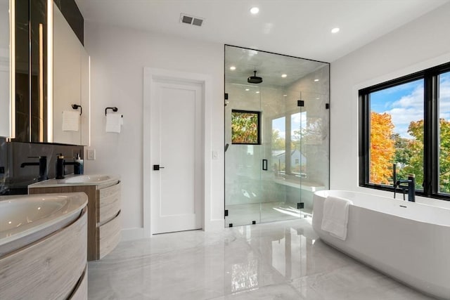 full bath featuring marble finish floor, two vanities, visible vents, a freestanding bath, and a stall shower