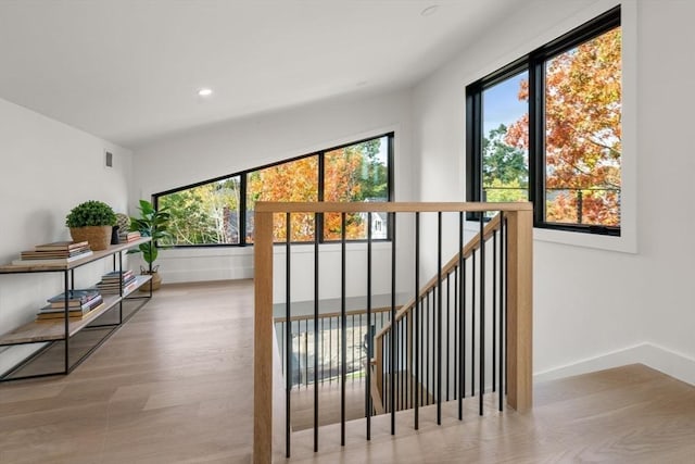 interior space with baseboards, wood finished floors, and recessed lighting