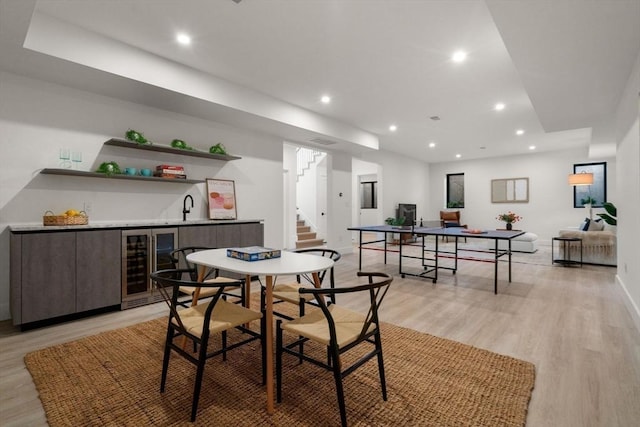 dining area with light wood-type flooring, beverage cooler, stairs, and recessed lighting