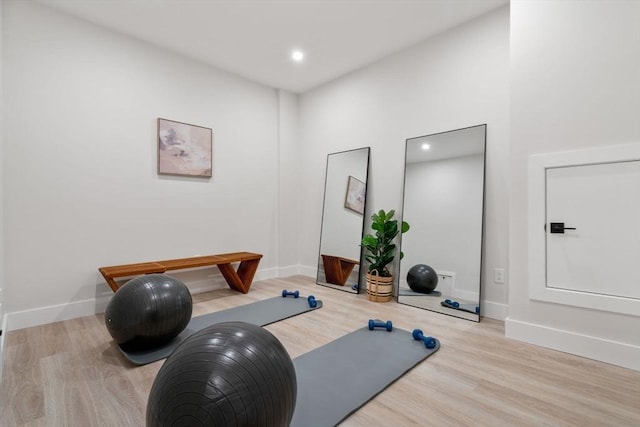 workout area featuring baseboards, wood finished floors, and recessed lighting