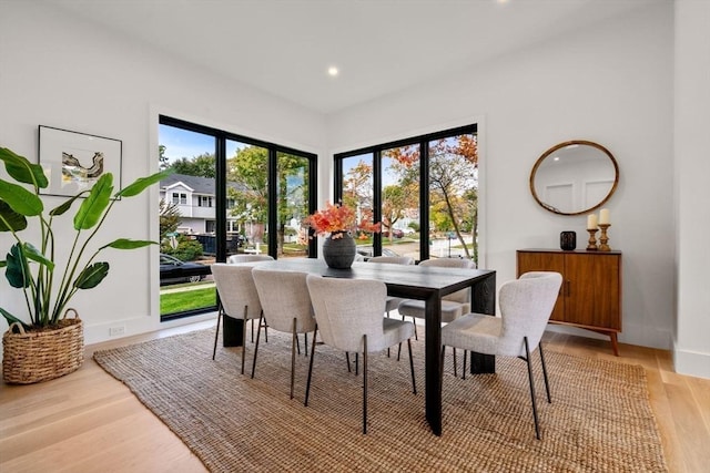 dining space with baseboards, light wood-style flooring, and recessed lighting