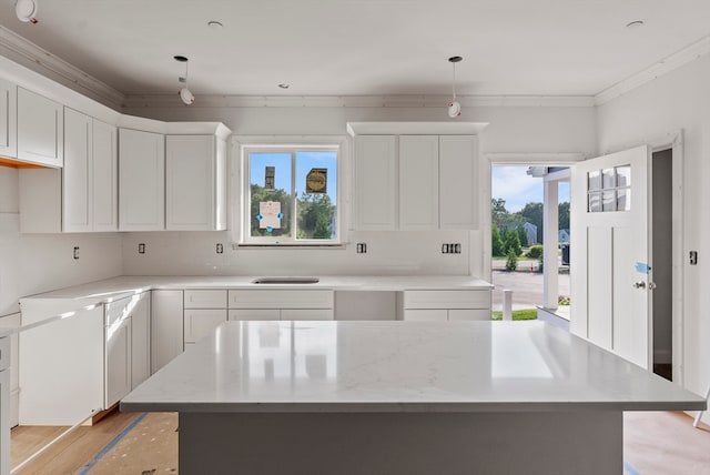 kitchen featuring white cabinets, decorative light fixtures, and a center island