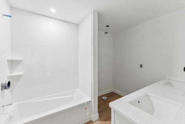 bathroom with hardwood / wood-style floors, vanity, and shower / tub combination