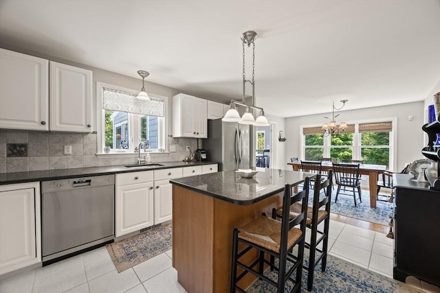 88 Amelia Way, Barnstable, MA 02648 - kitchen with stainless steel appliances, a kitchen breakfast bar, backsplash, white cabinetry, and a center island