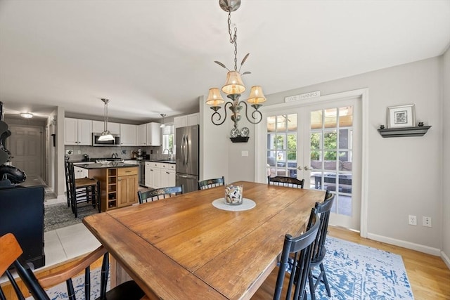 88 Amelia Way, Barnstable, MA 02648 - dining area with french doors, a chandelier, and light wood-style floors