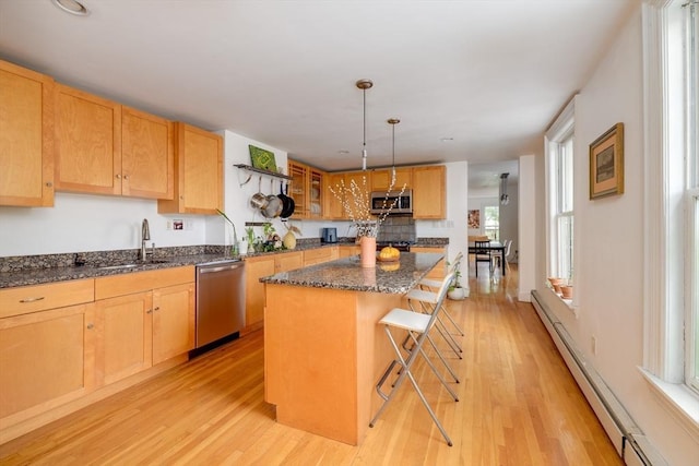46 Bigelow St Unit 3, Cambridge, MA 02139 - kitchen featuring appliances with stainless steel finishes, a sink, a kitchen island, light wood-type flooring, and baseboard heating