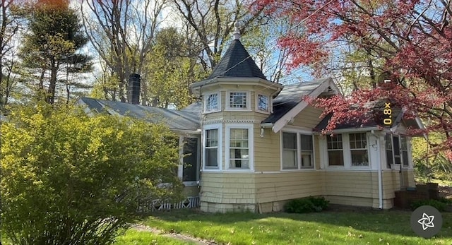 view of property exterior featuring a shingled roof and a yard
